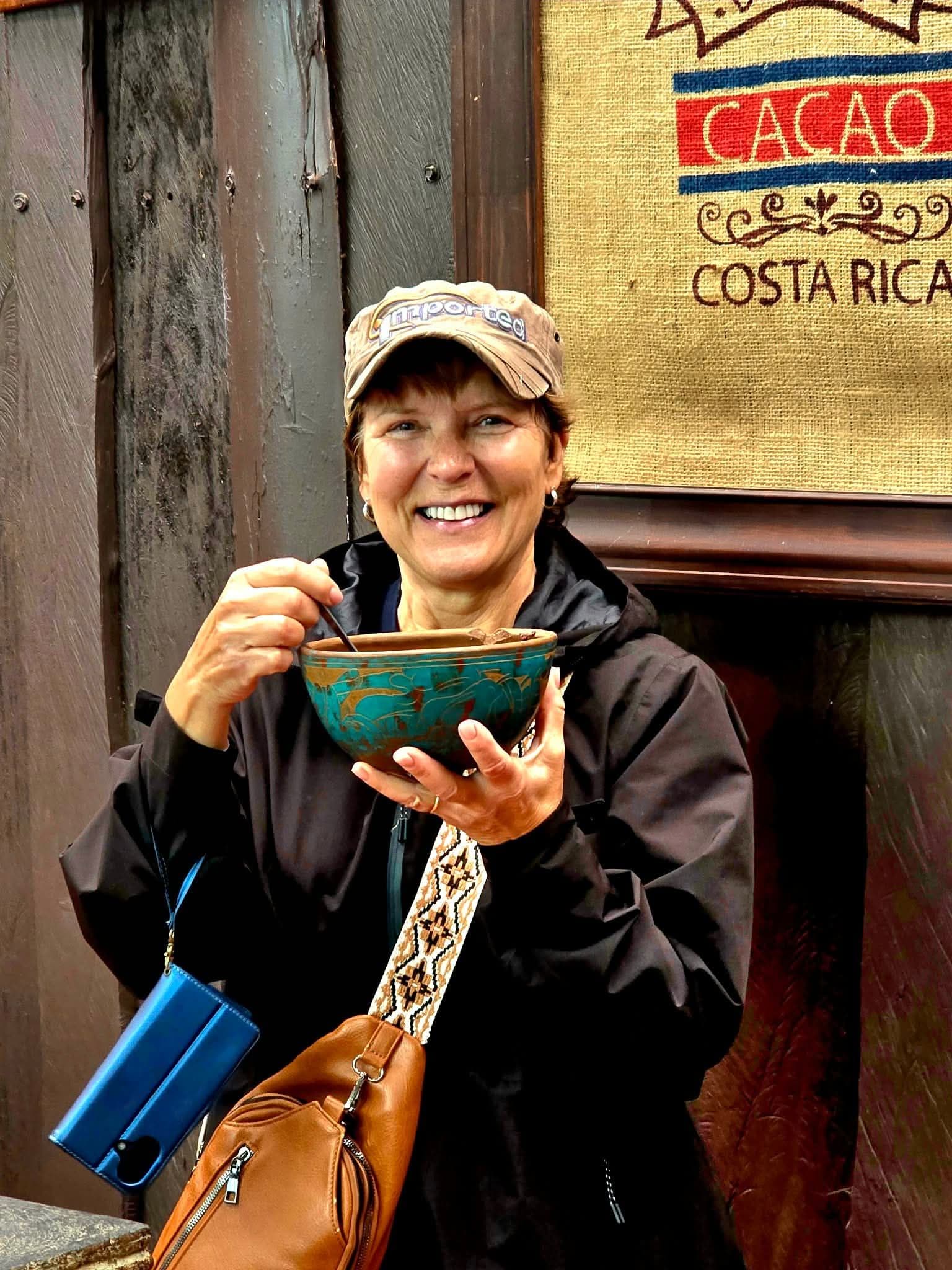 Woman tasting a hot drink from a decorative bowl during a Monteverde coffee tour, Costa Rica.